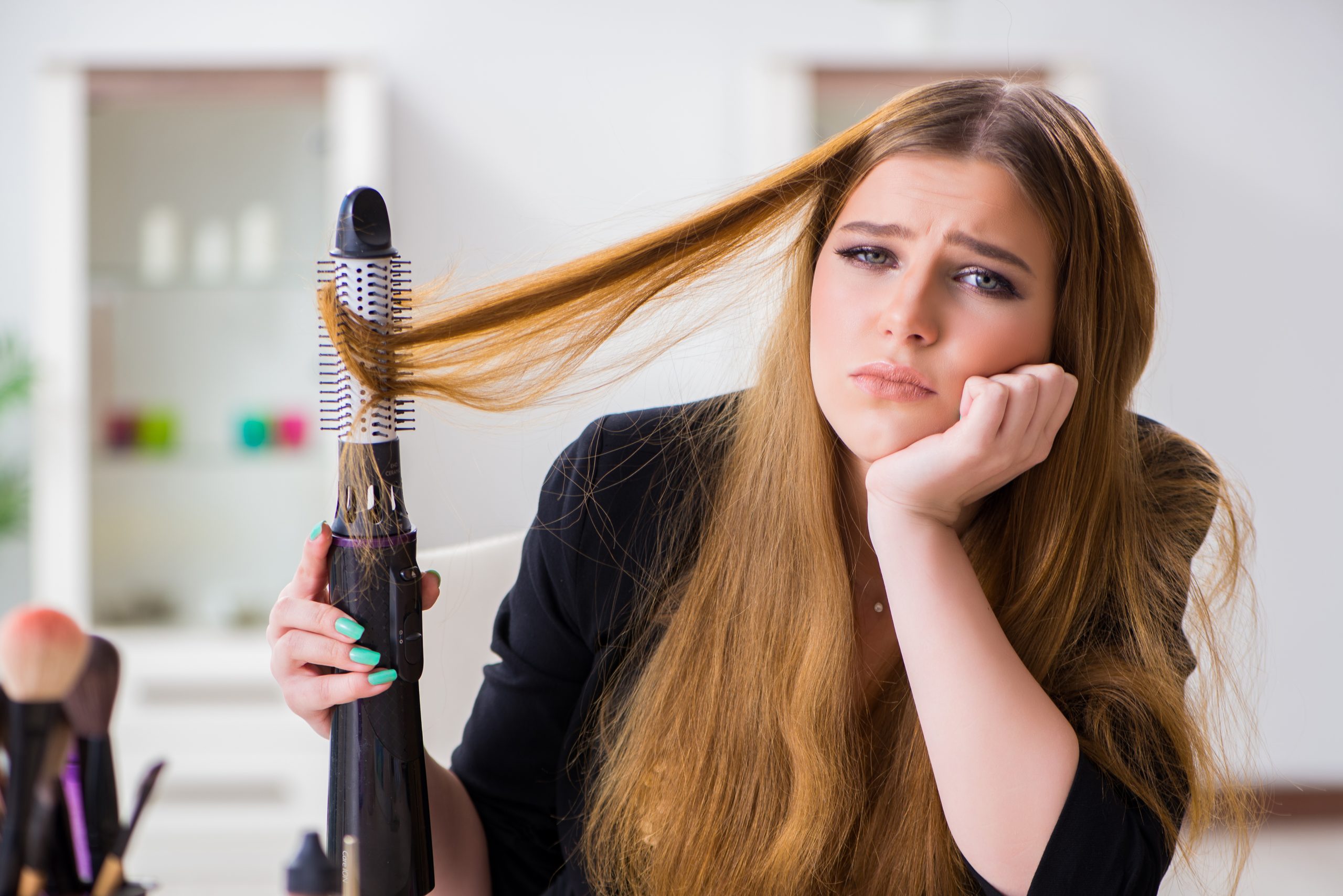 Cabeleireiro seca e modela o cabelo com um secador de cabelo no salão de  beleza